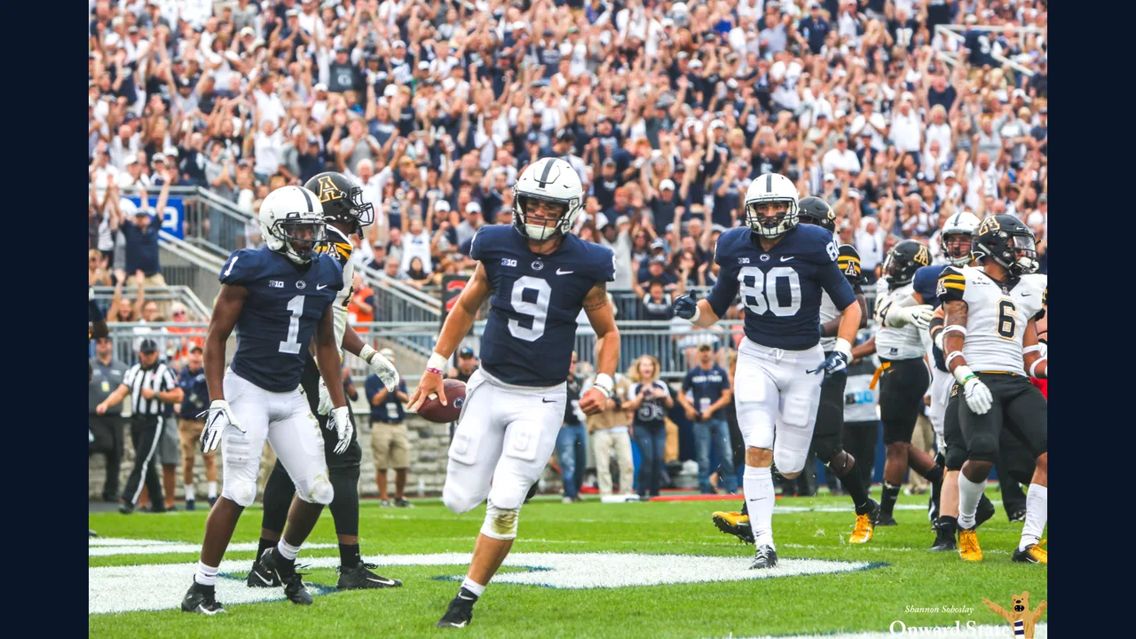College football players on the field in a packed stadium