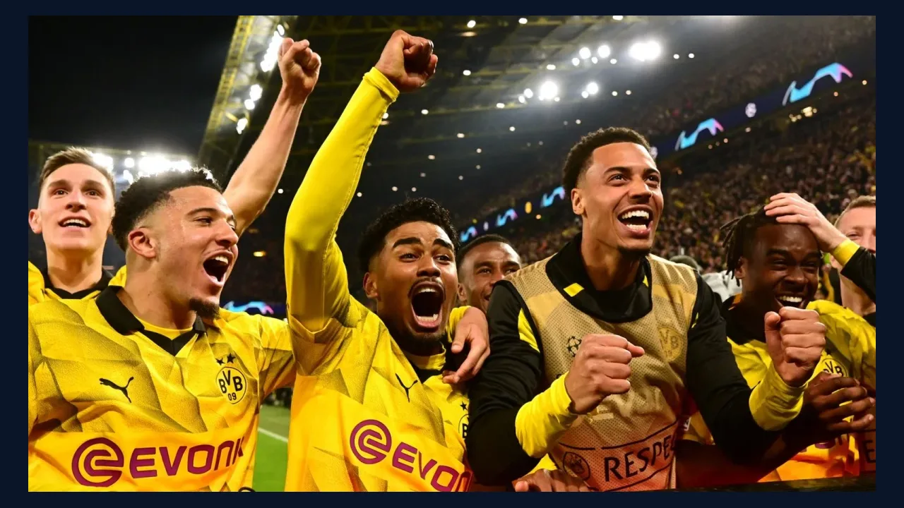 Football players celebrating under stadium floodlights at night